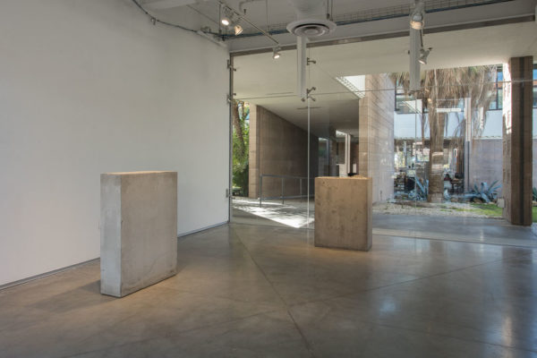 Lara Favaretto, <em>Boring</em>, 2010, Concrete, iron, 43 1/4 x 31 1/2 x 9 7/8 in (109.8 x 80 x 25 cm), and Lara Favaretto, <em>Fisting</em>, 2012 Concrete, iron, 39 1/8 x 17 1/4 x 29 1/4 in (99.4 x 43.8 x 74 cm), Glass Box Gallery, University California Santa Barbara, 2019, Courtesy MCASB, Photo: Brian Forrest.