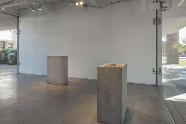 Lara Favaretto, <em>Boring</em>, 2010, Concrete, iron, 43 1/4 x 31 1/2 x 9 7/8 in (109.8 x 80 x 25 cm), and Lara Favaretto, <em>Fisting</em>, 2012 Concrete, iron, 39 1/8 x 17 1/4 x 29 1/4 in (99.4 x 43.8 x 74 cm), Glass Box Gallery, University California Santa Barbara, 2019, Courtesy MCASB, Photo: Brian Forrest.